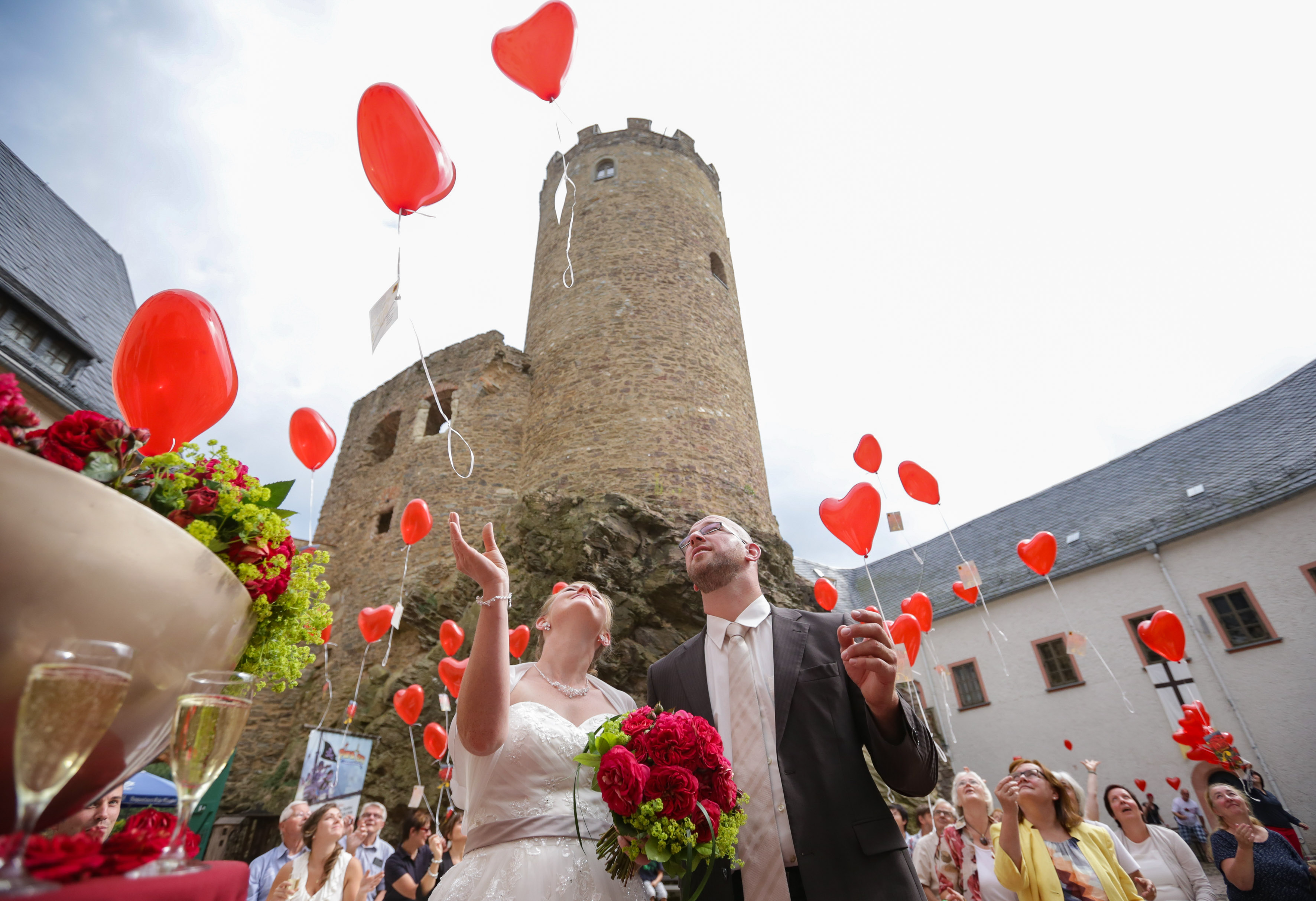Brautpaar lässt rote Herzluftballons steigen_Familienburg Scharfenstein
